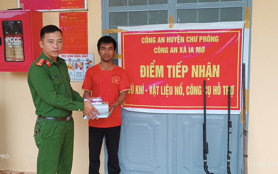 Người dân giao nộp súng tự chế đổi lấy vở, bút cho học sinh. Ảnh: Trịnh Thạch