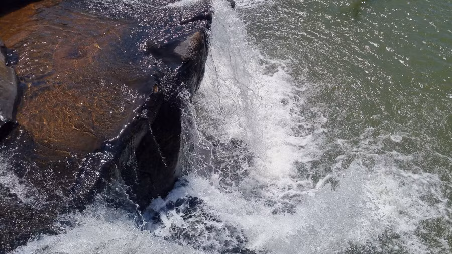 Tiếng ầm ào của thác đổ, tung bọt trắng xóa nổi bật giữa không gian rộng lớn.