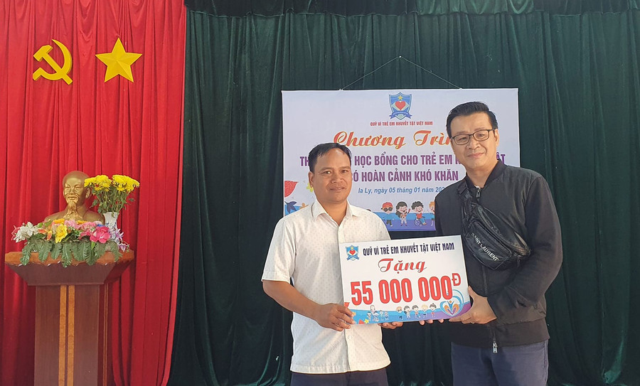 Đại diện Quỹ Vì trẻ em khuyết tật Việt Nam trao tượng trưng 50 triệu đồng để tặng học bổng cho các trẻ em khuyết tật có hoàn cảnh khó khăn tại thị trấn Ia Ly. Ảnh: T.L