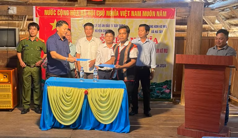 Đại diện Ban Quản lý các dự án đầu tư xây dựng huyện Chư Păh và làng Kon Kơ Mŏ ký bản giao ước kết nghĩa. Ảnh: V.Đ