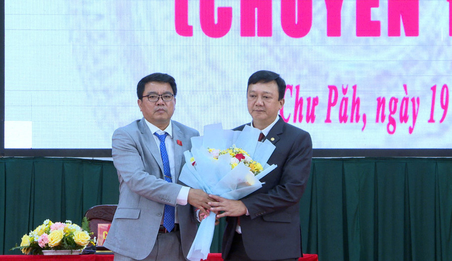 Ông Nay Kiên-Bí thư Huyện ủy, Chủ tịch HĐND huyện Chư Păh (bên trái) tặng hoa chúc mừng ông Nguyễn Hữu Nguyên-tân Chủ tịch UBND huyện. Ảnh: K.P