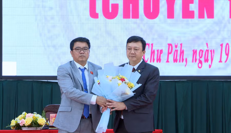 Ông Nay Kiên-Bí thư Huyện ủy, Chủ tịch HĐND huyện Chư Păh (bên trái) tặng hoa chúc mừng ông Nguyễn Hữu Nguyên-tân Chủ tịch UBND huyện. Ảnh: K.P