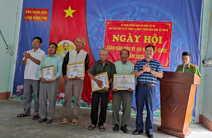 Khen thưởng các cá nhân có thành tích xuất sắc trong xây dựng phòng trào toàn dân bảo vệ an ninh Tổ quốc tại làng Bông Pim, xã Đak Jơ Ta. Ảnh: Kim Ngọc