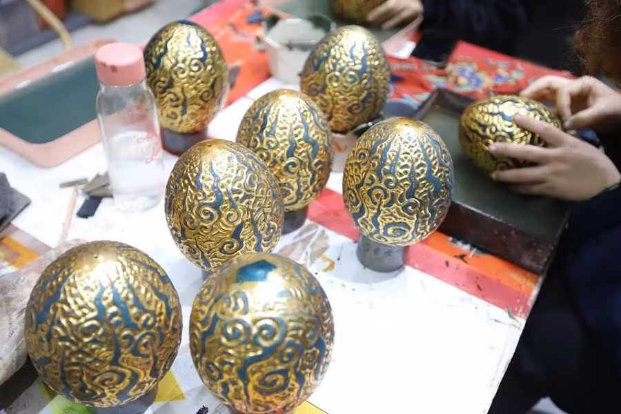 Những quả trứng rồng được làm từ gỗ hương cùng chất liệu sơn mài truyền thống. Vỏ trứng là hoa văn mây lửa cách điệu từ đồ án văn hóa trên bậc thềm đá Điện Kính Thiện - Bảo vật Quốc gia tại Hoàng Thành Thăng Long. Những đám mây cuồn cuộn với ý nghĩa mưa thuận gió hòa, mùa màng bội thu.