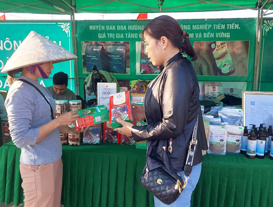 Bà Liên (bên phải) đang giới thiệu các sản phẩm của cơ sở đến người tiêu dùng. Ảnh: N.D