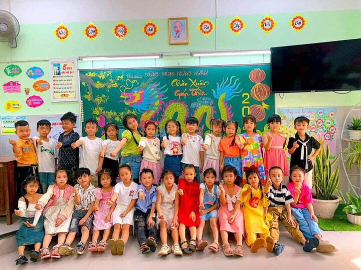 Các em học sinh thích thú chụp ảnh cùng tranh vẽ