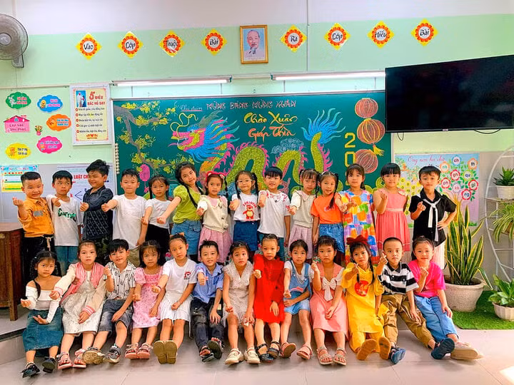 Các em học sinh thích thú chụp ảnh cùng tranh vẽ