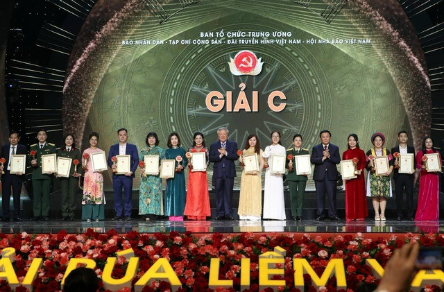 Chánh án Tòa án Nhân dân tối cao Nguyễn Hòa Bình và Giám đốc Học viện Chính trị quốc gia Hồ Chí Minh Nguyễn Xuân Thắng trao giải C cho các tác giả, nhóm tác giả có tác phẩm đoạt giải. Ảnh: Nhật Bắc