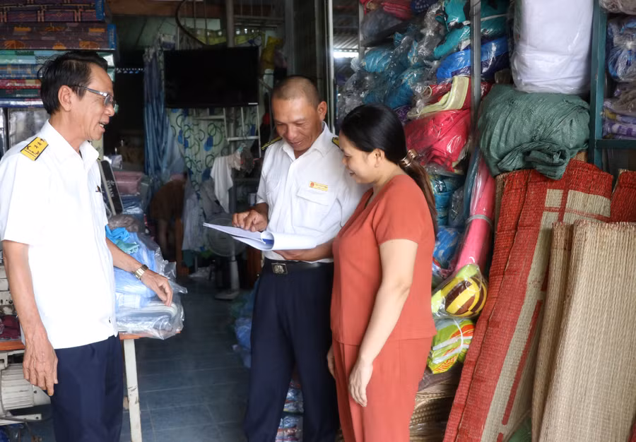 Ông Võ Đời (bìa trái)-Phó Bí thư chi bộ, Đội trưởng Đội Nghiệp vụ quản lý thuế (Chi cục Thuế huyện Kbang) cùng cán bộ thuế kiểm tra công tác nộp thuế của hộ kinh doanh. Ảnh: Ngọc Minh