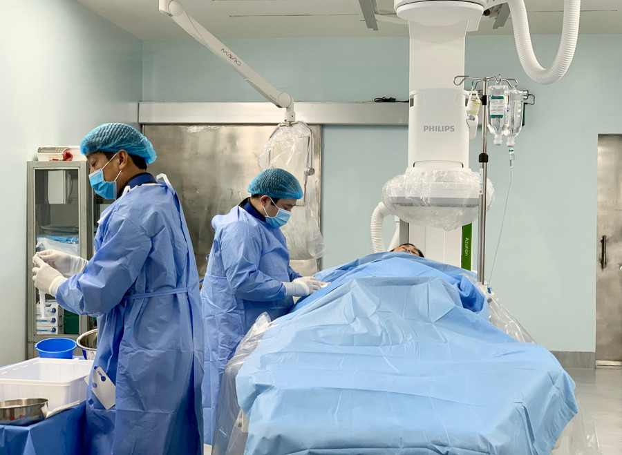 Bác sĩ Toán (bên trái) cùng đồng nghiệp chuẩn bị ca chụp mạch bằng hệ thống máy DSA cho bệnh nhân. Ảnh: Như Nguyện Bác sĩ Toán (bên trái) cùng đồng nghiệp chuẩn bị ca chụp mạch bằng hệ thống máy DSA cho bệnh nhân. Ảnh: Như Nguyện