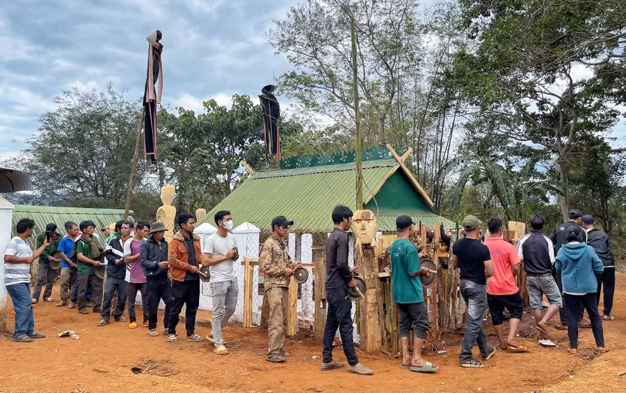 Dân làng đánh cồng chiêng quanh khu nhà mồ để tiễn người chết về cõi Atâu, chấm dứt mọi ràng buộc với người sống. Ảnh: Hoàng Ngọc