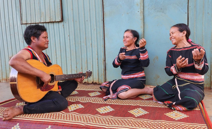 Vợ chồng ông Tanh, bà Lơch và người cháu gái Mlach (bìa phải) cùng đàn hát một ca khúc dân ca Bahnar. Ảnh: D.T Vợ chồng ông Tanh, bà Lơch và người cháu gái Mlach (bìa phải) cùng đàn hát một ca khúc dân ca Bahnar. Ảnh: D.T