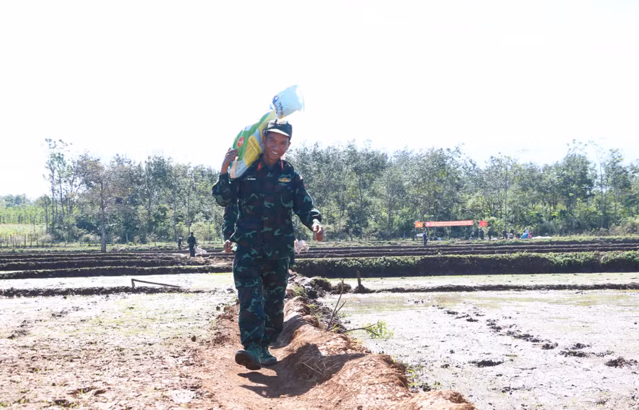 Chiến sĩ Y Hội Bkrông (Trung đoàn 66) rất vui khi được giúp người dân làng Thơ Ga B. Ảnh: Q.T