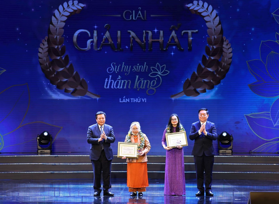 Ông Nguyễn Xuân Thắng, Ủy viên Bộ Chính trị, Giám đốc Học viện Chính trị quốc gia Hồ Chí Minh, Chủ tịch Hội đồng Lý luận Trung ương và ông Nguyễn Trọng Nghĩa, Bí thư Trung ương Đảng, Trưởng ban Tuyên giáo Trung ương trao giải Nhất cho tác giả và chứng nhận cho nhân vật trong tác phẩm đoạt giải. (Ảnh: Thống Nhất/TTXVN)