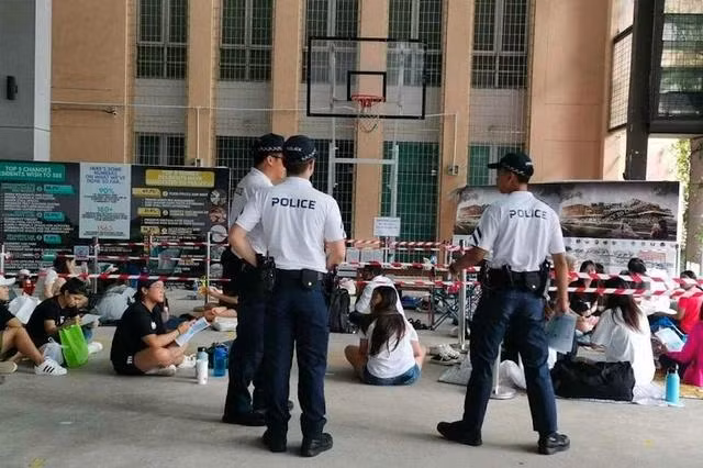 Cảnh sát Singapore phát áp phích cảnh báo lừa đảo cho người hâm mộ xếp hàng chờ mua vé Taylor Swift trong đợt mở bán vé hồi tháng 7.2023