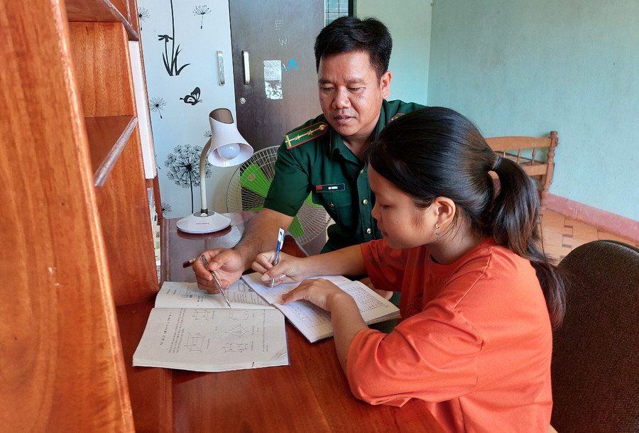 Bộ đội Biên phòng chỉ dạy con nuôi học bài. Ảnh: V.H Bộ đội Biên phòng chỉ dạy con nuôi học bài. Ảnh: V.H