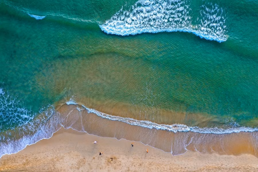 Nước biển trong xanh tung bọt trắng xóa khi vỗ vào bờ cát mịn màng ở bãi biển Mỹ Khê. (Ảnh: Trần Lê Lâm/TTXVN)