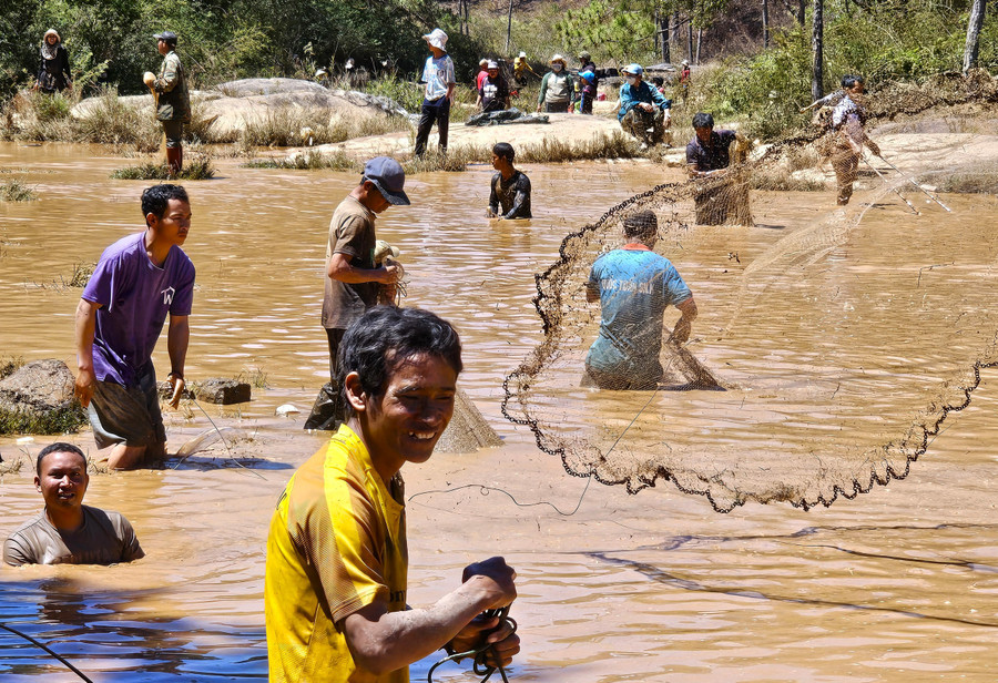 Trời càng trưa nắng, số lượng người đổ về đánh bắt cá tạo nên khung cảnh nhộn nhịp.