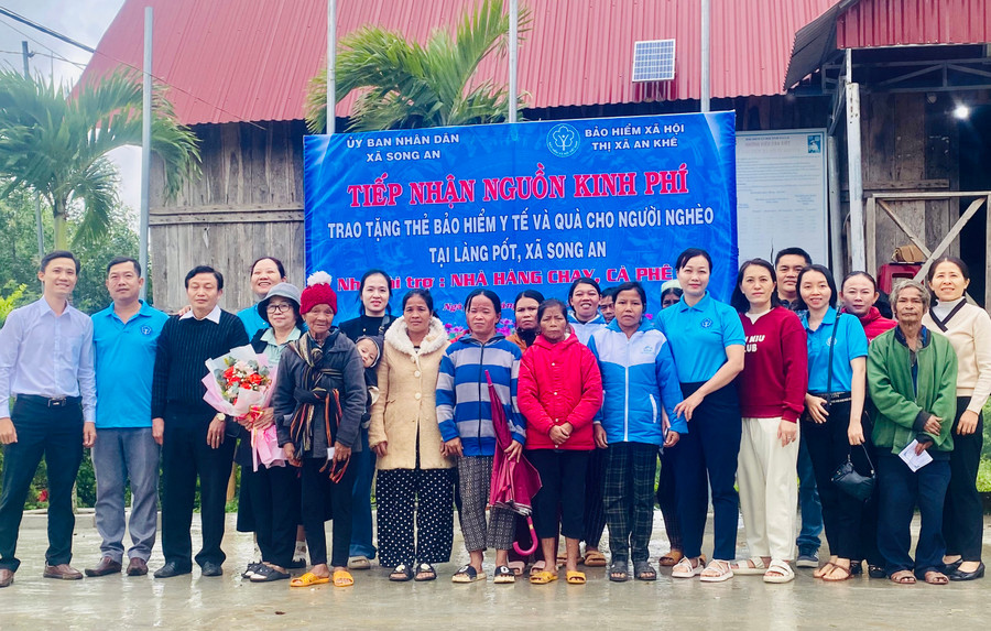 Trao tặng thẻ BHYT cho người dân làng Pốt, xã Song An, thị xã An Khê. Ảnh: N.N