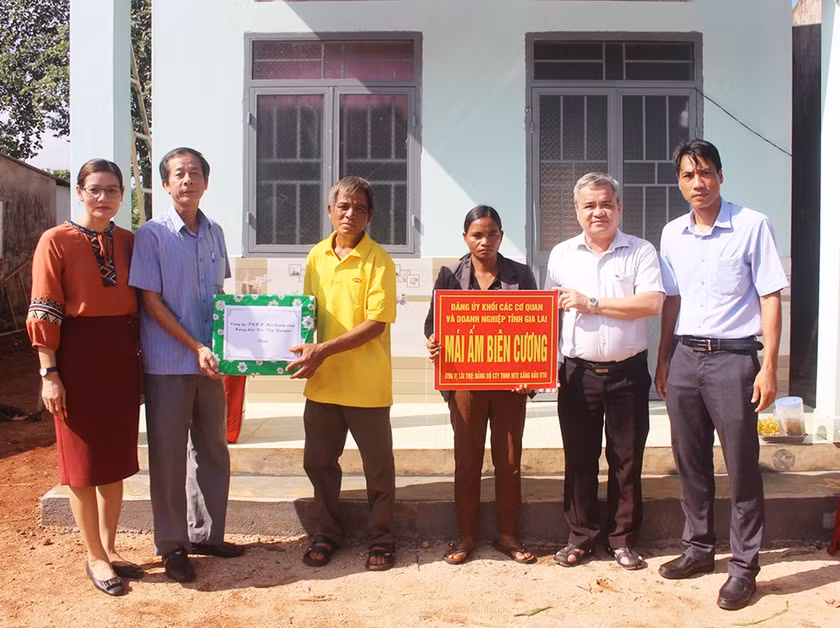 Phó Bí thư Thường trực Đảng ủy Khối các Cơ quan và Doanh nghiệp tỉnh Dương Dã (thứ 2 từ phải sang) cùng đại diện lãnh đạo UBND huyện Đức Cơ trao “Mái ấm biên cương” cho bà Rơ Châm H’Nak (làng Mook Đen 1, xã Ia Dom). Ảnh: Phan Lài