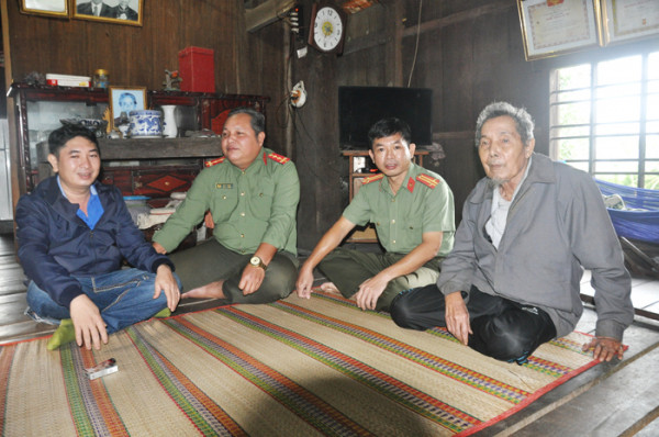 Già làng Ma Vi (bìa phải) trò chuyện với cán bộ, chiến sĩ Công an tỉnh Phú Yên về chuyện dạy và học tiếng Êđê.