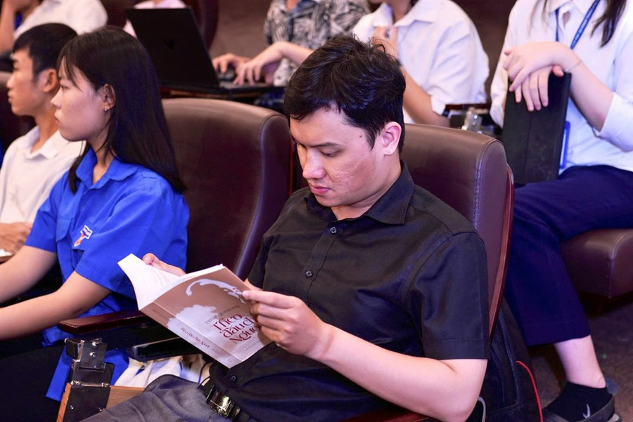 Bạn đọc đọc tác phẩm Theo dấu chân Người tại buổi tọa đàm