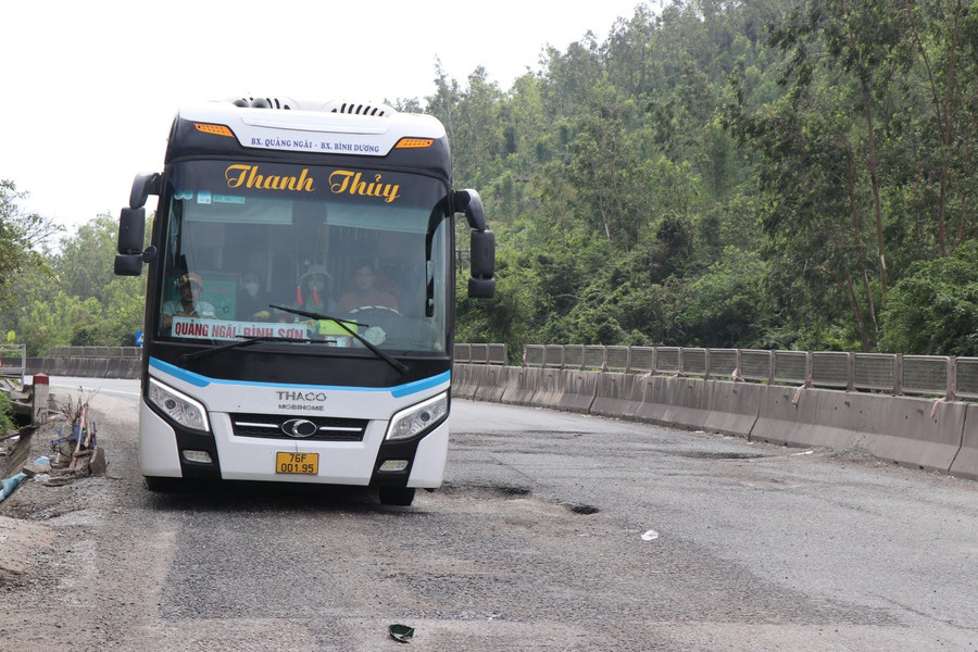 Tuy phải leo dốc qua đoạn Quốc lộ 1 ở phường Phổ Thạnh, nhưng nhiều tài xế phải nhích từng chút vì đoạn đường trên có rất nhiều &quot;ổ voi&quot;, &quot;ổ gà&quot;, tiềm ẩn nguy cơ tai nạn. Ảnh: Ngọc Viên