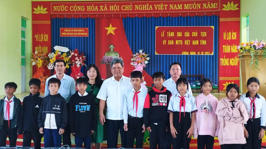 Chủ tịch Ủy ban MTTQ Việt Nam tỉnh Hồ Văn Điềm chụp ảnh lưu niệm với giáo viên và học sinh Trường Tiểu học và THCS Trần Hưng Đạo tại buổi trao quà. Ảnh: Lê Đại