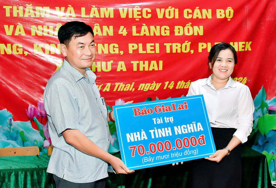 Tổng Biên tập Báo Gia Lai Huỳnh Kiên (bên trái) tặng tượng trưng 1 căn nhà cho gia đình chính sách ở địa phương trị giá 70 triệu đồng. Ảnh: Đ.T Tổng Biên tập Báo Gia Lai Huỳnh Kiên (bên trái) tặng tượng trưng 1 căn nhà cho gia đình chính sách ở địa phương trị giá 70 triệu đồng. Ảnh: Đ.T