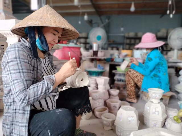 Tỉ mỉ chấm men lên sản phẩm gốm