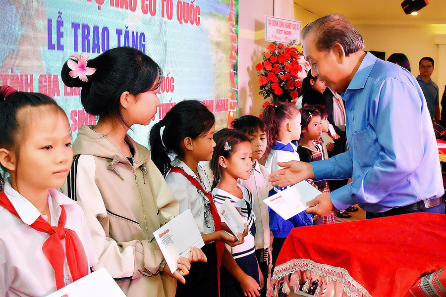 Đồng chí Trương Hòa Bình-nguyên Ủy viên Bộ Chính trị, nguyên Phó Thủ tướng Thường trực Chính phủ trao học bổng cho các em học sinh nghèo học giỏi. Ảnh: Đ.T