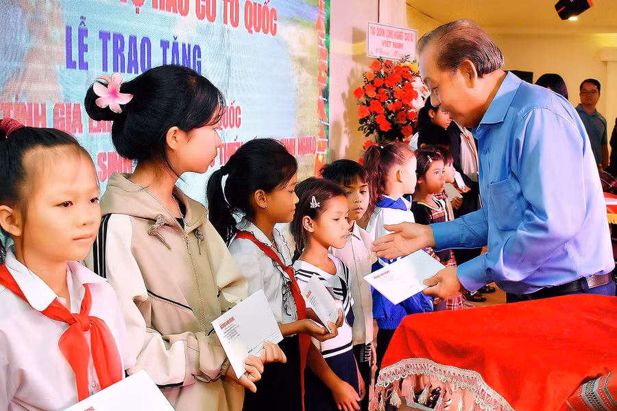 Đồng chí Trương Hòa Bình-nguyên Ủy viên Bộ Chính trị, nguyên Phó Thủ tướng Thường trực Chính phủ trao học bổng cho các em học sinh nghèo học giỏi. Ảnh: Đ.T