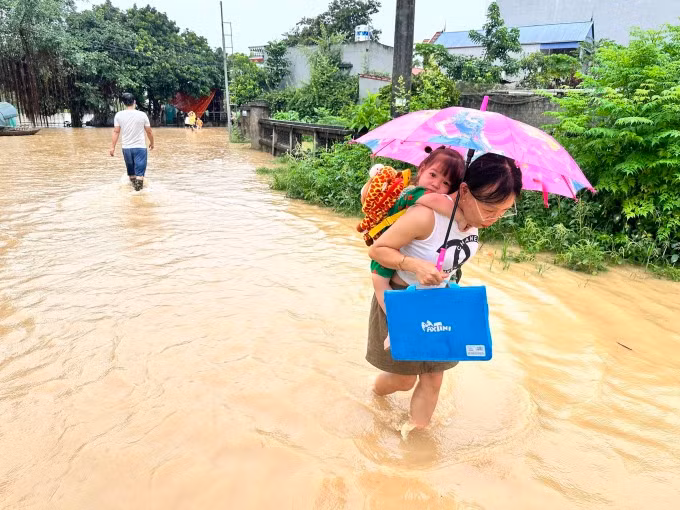 Người dân ngoại thành Hà Nội cõng con qua đường ngập đến trường ngày 257. Ảnh: Gia Chính/Nguồn vnexpress.net Người dân ngoại thành Hà Nội cõng con qua đường ngập đến trường ngày 257. Ảnh: Gia Chính/Nguồn vnexpress.net