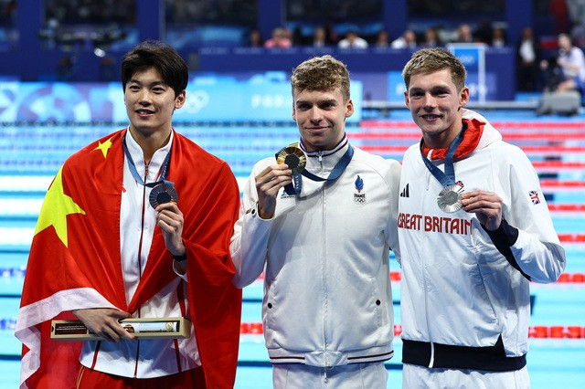 Leon Marchand đánh bại ĐKVĐ Wang Shun (trái)