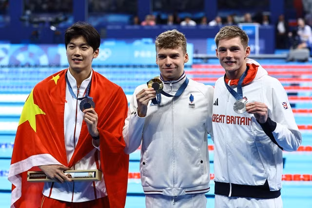 Leon Marchand đánh bại ĐKVĐ Wang Shun (trái)