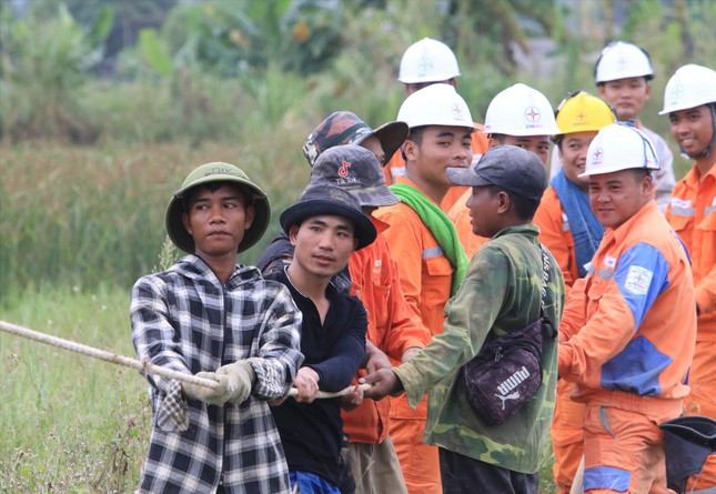 Anh Hoàng Văn Tiến (SN 1993, trú tỉnh Hòa Bình - áo đen) đang cùng đồng nghiệp kéo dây, dựng cột điện Anh Hoàng Văn Tiến (SN 1993, trú tỉnh Hòa Bình - áo đen) đang cùng đồng nghiệp kéo dây, dựng cột điện