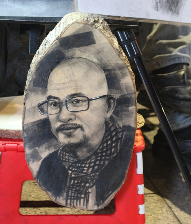 Ngoài vẽ ký họa trên giấy, anh Lộc còn nhận vẽ ký họa trên mặt gỗ Ngoài vẽ ký họa trên giấy, anh Lộc còn nhận vẽ ký họa trên mặt gỗ