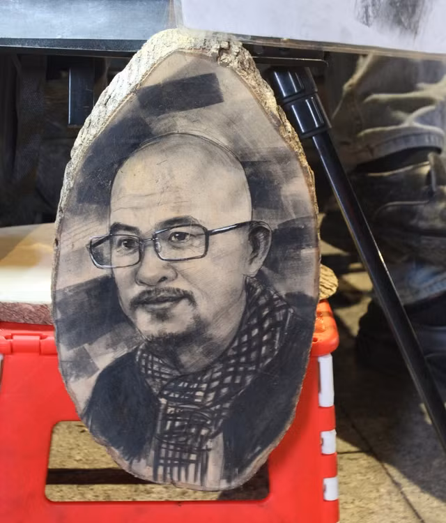 Ngoài vẽ ký họa trên giấy, anh Lộc còn nhận vẽ ký họa trên mặt gỗ Ngoài vẽ ký họa trên giấy, anh Lộc còn nhận vẽ ký họa trên mặt gỗ