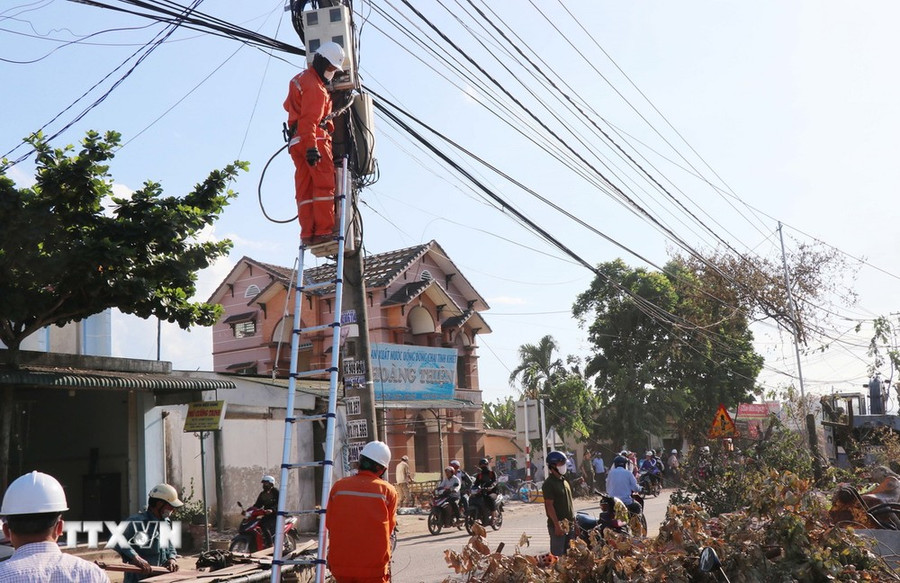 Điện lực Quảng Ngãi hỗ trợ người dân di dời lưới điện. (Ảnh: Phạm Cường/TTXVN)