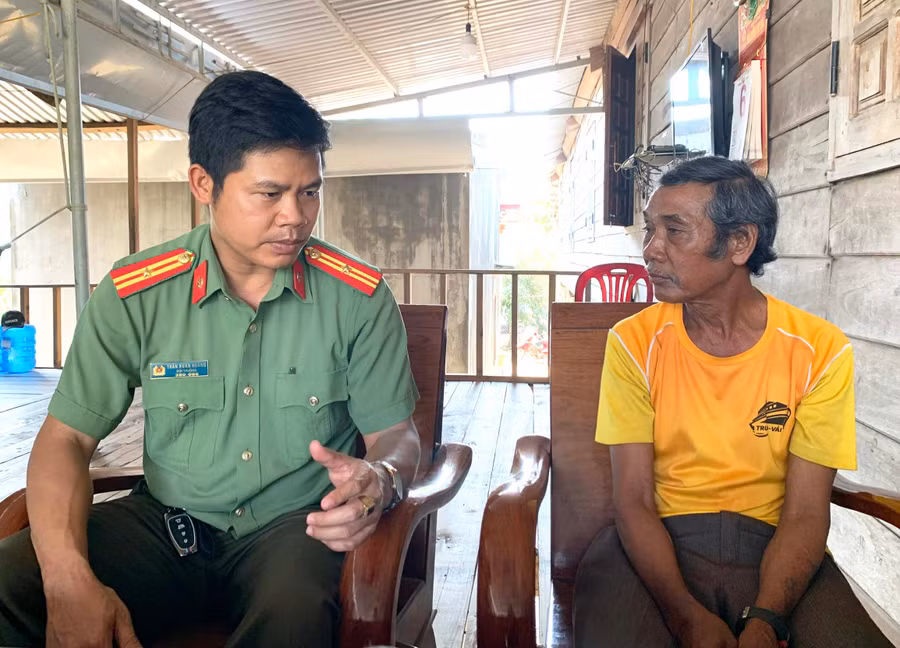 Thiếu tá Trần Xuân Hoàng (bìa trái) tuyên truyền cho người dân về hành vi sai trái của Tin lành Đê ga. Ảnh: R.H