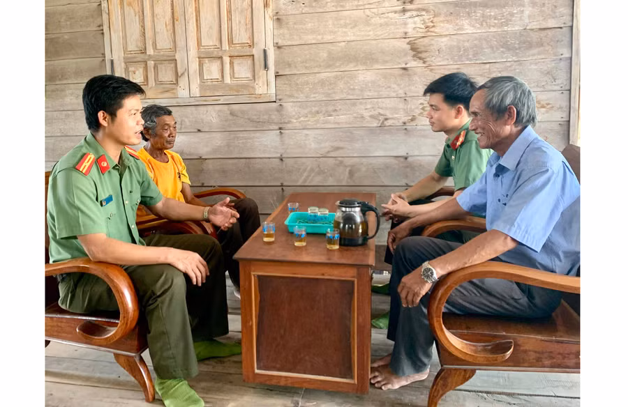 Thiếu tá Trần Xuân Hoàng (bìa trái) thường xuyên tuyên truyền, vận động người dân chấp hành nghiêm các quy định của pháp luật. Ảnh: R.H