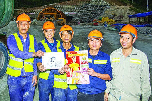 Công nhân tươi cười với tấm ảnh chị Trâm trước cửa hầm số 2. Ảnh: Văn Chương Công nhân tươi cười với tấm ảnh chị Trâm trước cửa hầm số 2. Ảnh: Văn Chương
