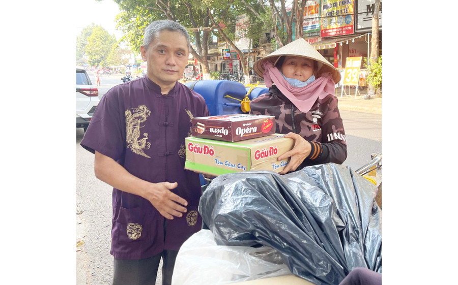 Ông Huỳnh Duy Nghĩa tặng mì tôm và bánh cho những người có hoàn cảnh khó khăn. Ảnh: P.D