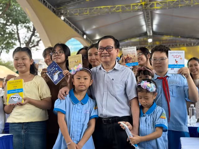 Các em thiếu nhi hào hứng chụp ảnh lưu niệm cùng tác giả những cuốn sách yêu thích của mình. Ảnh: Mai Nhật