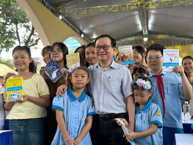 Các em thiếu nhi hào hứng chụp ảnh lưu niệm cùng tác giả những cuốn sách yêu thích của mình. Ảnh: Mai Nhật