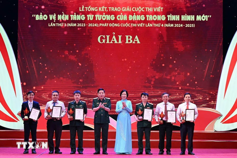 Trung tướng Nguyễn Văn Gấu, Phó chủ nhiệm Tổng cục Chính trị Quân đội nhân dân Việt Nam và đồng chí Vũ Việt Trang, Tổng Giám đốc Thông tấn xã Việt Nam trao giải cho các tác giả, nhóm tác giả đoạt giải Ba. (Ảnh: Thanh Tùng/TTXVN)