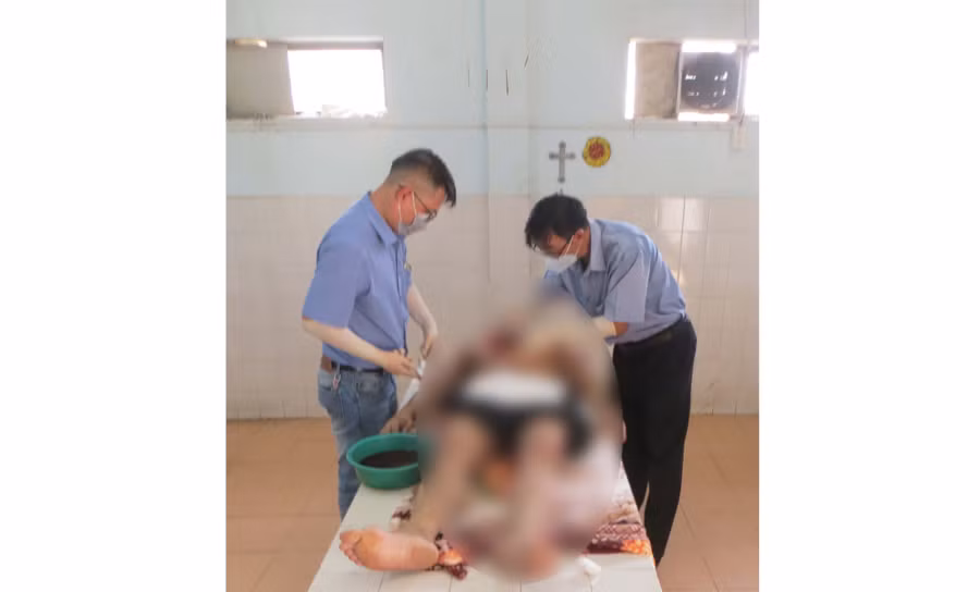 Bác sĩ Đồng Xuân Đức (bìa trái) đang khám nghiệm tử thi. Ảnh: N.T