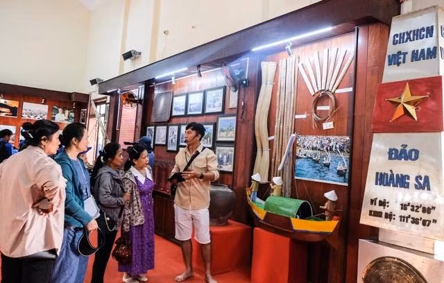 Du khách tham quan triển lãm hình ảnh, tư liệu liên quan đến lễ khao lề thế lính Hoàng Sa ở đảo Lý Sơn (Quảng Ngãi)