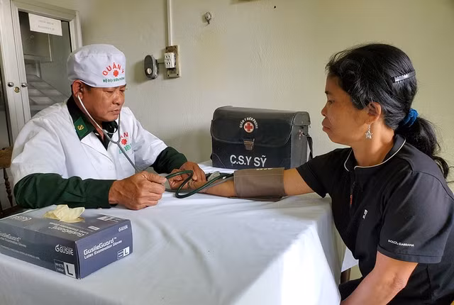 Thiếu tá, y sĩ Bùi Công Trọng khám bệnh cho chị A Viết Thị Thôn, 40 tuổi, đến từ bản Ka Lôi, H.Ka Lùm (Lào)