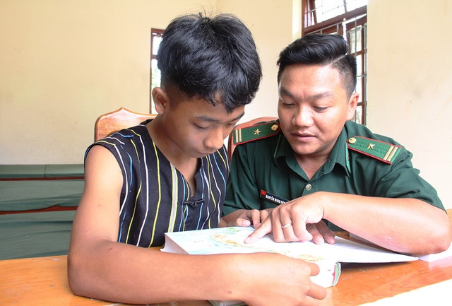Thiếu tá Nguyễn Minh Vương hướng dẫn Zơ Râm Dũng xem bản đồ